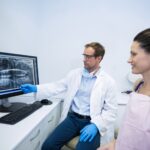 Dentist showing an x-ray of teeth to female patient